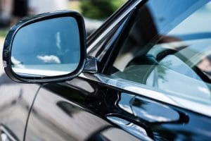 close up view of front car mirror with reflection