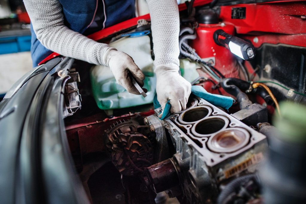 Man mechanic repairing a car in a garage.